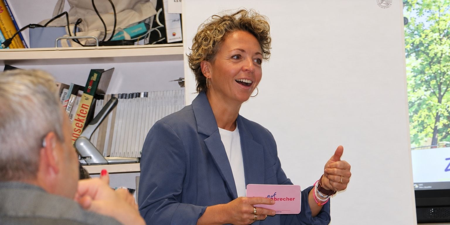 Eine Teilnehmerin spricht mit Moderationskarten beim Programmtag.