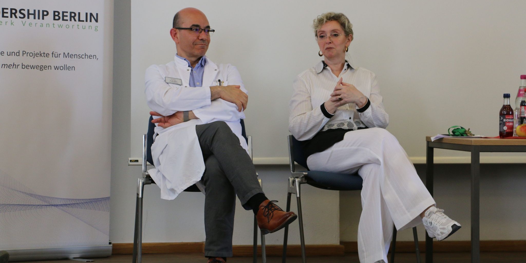Zwei Gesprächspartner*innen aus dem Krankenhaus sprechen vor der Gruppe.