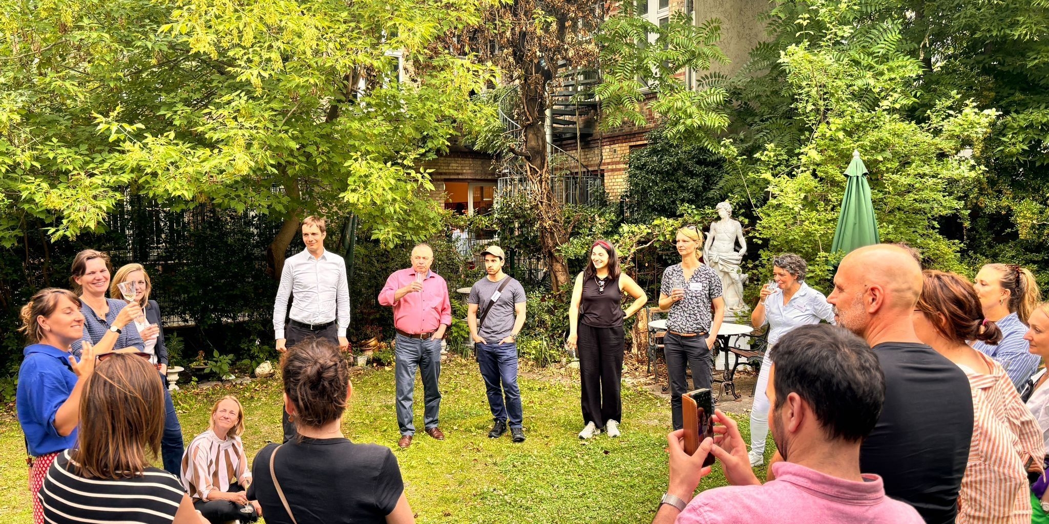 Teilnehmende tauschen sich im Garten des Jüdischen Krankenhauses aus.