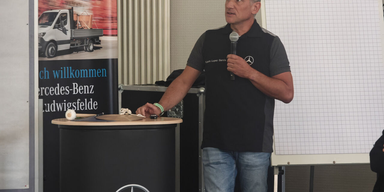 Ein Referent spricht am Rednerpult beim Programmtag bei Mercedes-Benz in Ludwigsfelde.