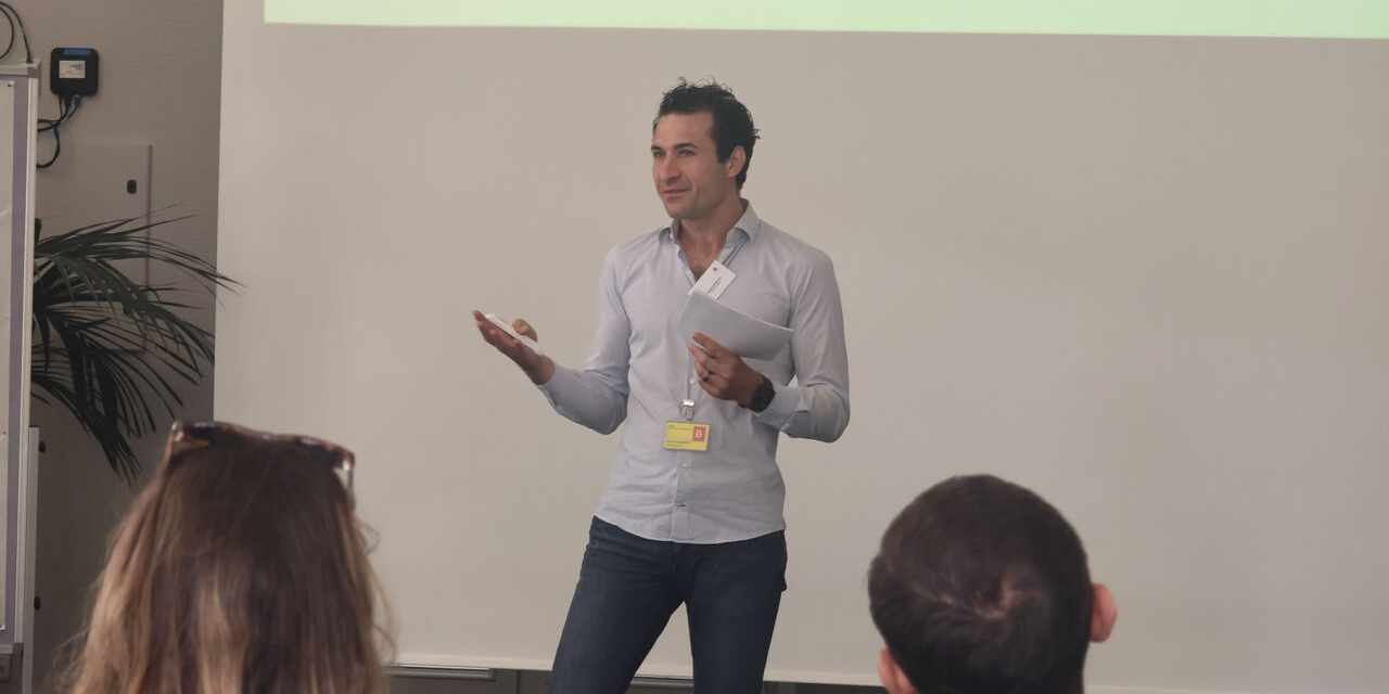Ein Referent erläutert eine Präsentation zum Wissensmanagement.